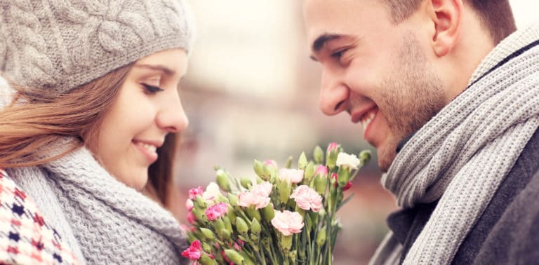 A picture of a man giving flowers to his lover on a winter day