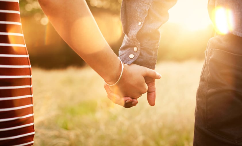 sunset couple holding hands