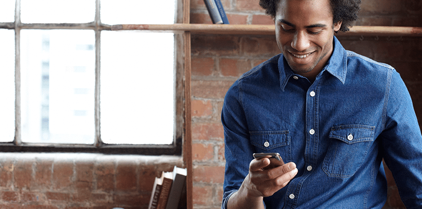 happy man chatting with someone through smartphone